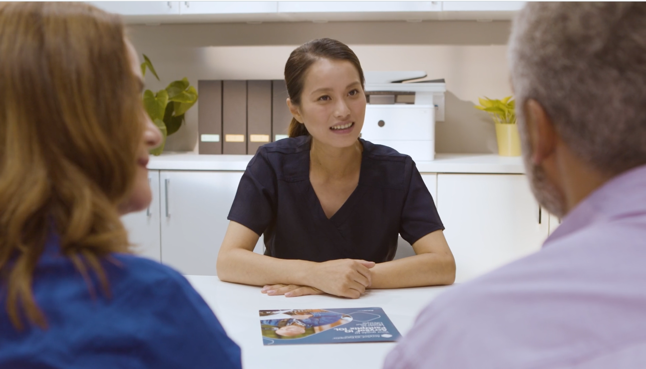 Female doctor having a conversation with an older couple, discussing IOL options for cataracts.